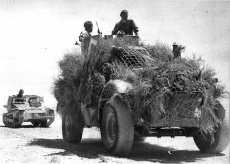 An Armoured Car of King's Dragoon Guards, towing away a 'prize' in the shape of an Italian L-3 Tankette armed with twin 8mm machine guns, after the Battle of Beda Fomm